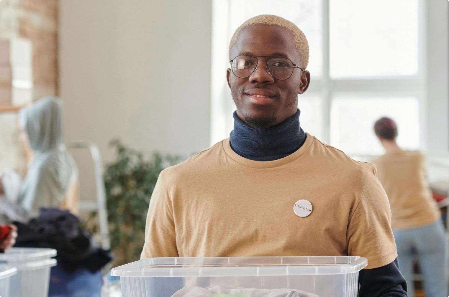 A volunteer smiling while sorting donations with their team